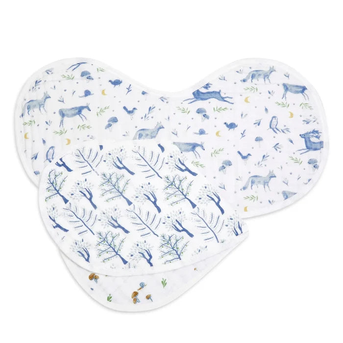 Two muslin baby bibs with blue woodland animal and tree patterns, arranged overlapping on a white background.