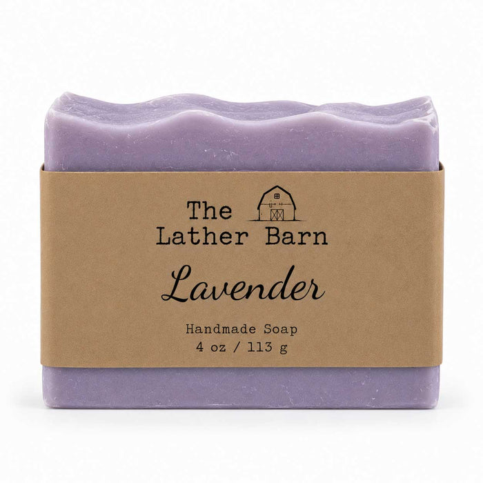A single bar of lavender handmade soap wrapped in a kraft paper band labeled 'The Lather Barn Lavender', shown on a clean white background.