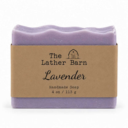 A single bar of lavender handmade soap wrapped in a kraft paper band labeled 'The Lather Barn Lavender', shown on a clean white background.