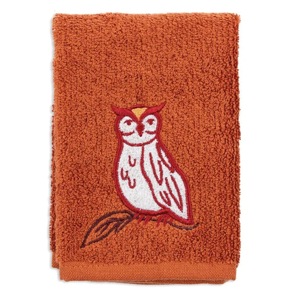 An orange terry cloth towel featuring an embroidered owl on a branch in red, white, and brown, set against a plain white background.